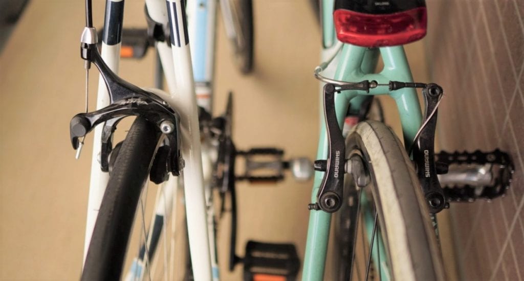 フラットバーロードのキャリパーブレーキ（左）と、クロスバイクのVブレーキ（右）